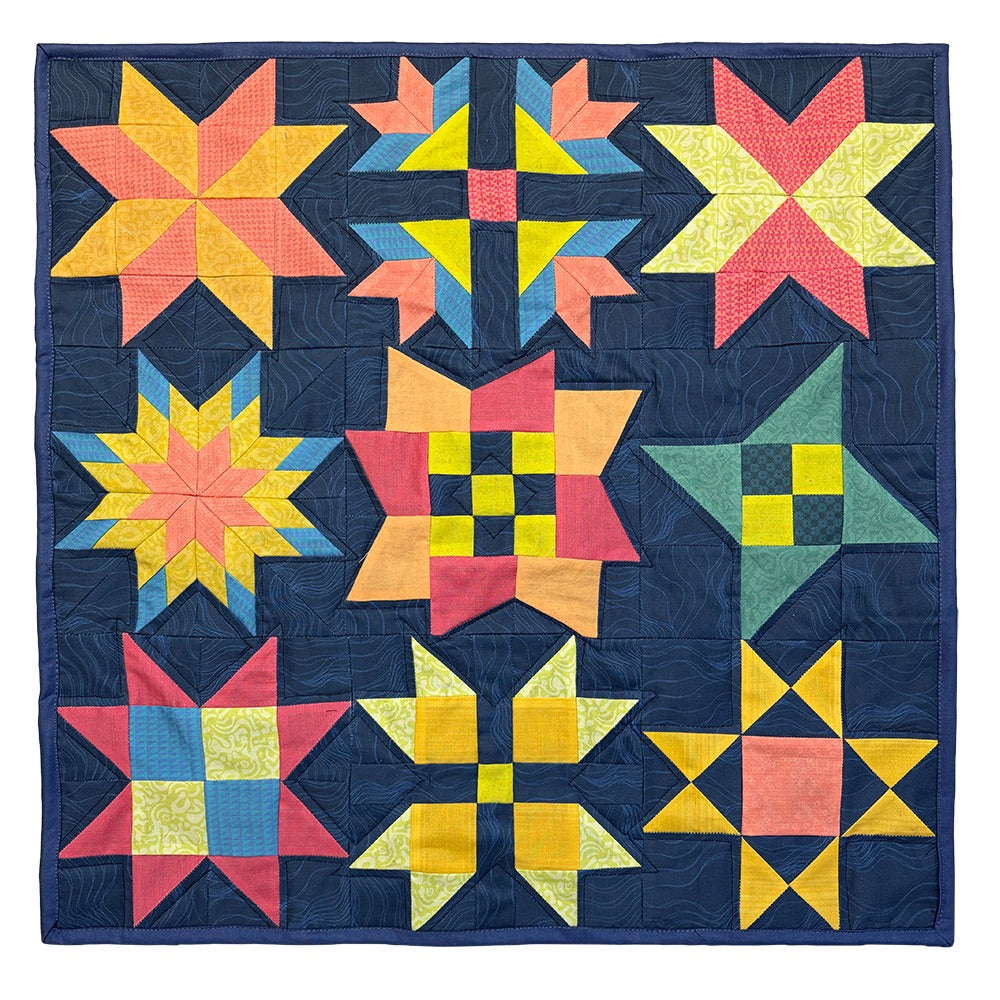 Finished Midnight Stars mini quilt, nine bright pieced stars on a navy background